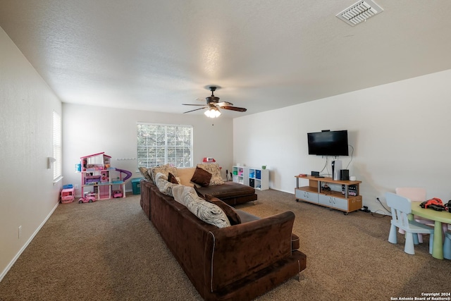 living room with a textured ceiling, carpet floors, and ceiling fan