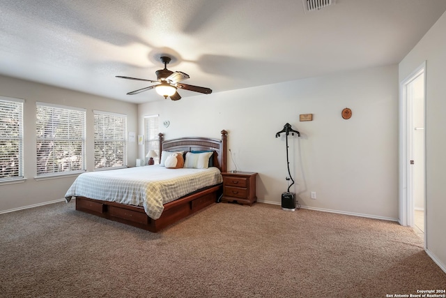 bedroom featuring ceiling fan, carpet flooring, and a textured ceiling