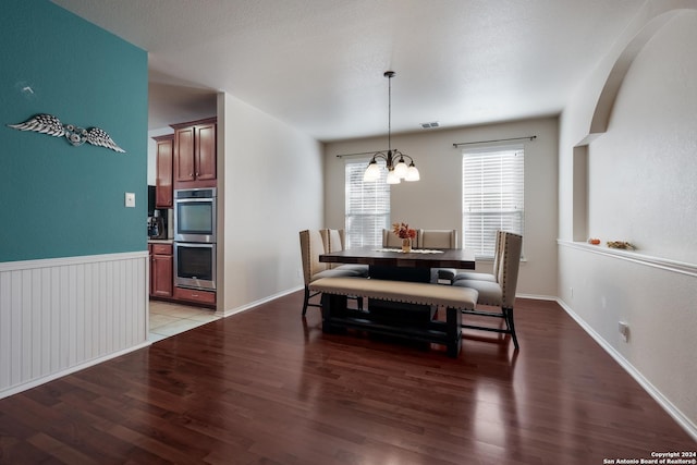 dining area featuring a notable chandelier and dark wood-type flooring