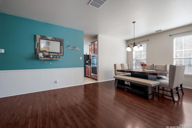 dining room featuring an inviting chandelier, dark hardwood / wood-style flooring, and plenty of natural light