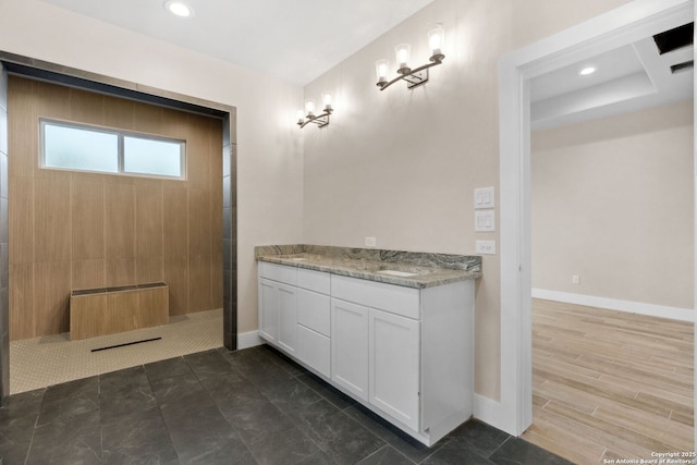 bathroom featuring vanity, wood-type flooring, and tiled shower