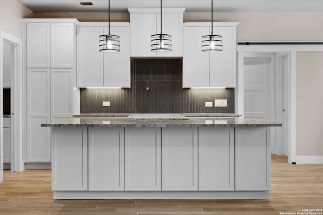 kitchen with white cabinetry, hanging light fixtures, and a center island