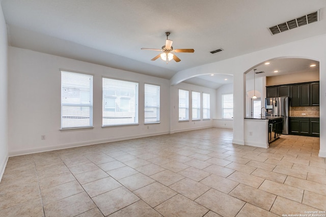 kitchen with stainless steel refrigerator with ice dispenser, light tile patterned flooring, sink, ceiling fan, and decorative backsplash