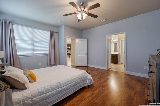 bedroom with connected bathroom, hardwood / wood-style floors, and ceiling fan