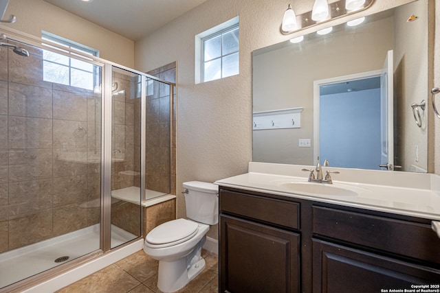 bathroom featuring an enclosed shower, vanity, tile patterned flooring, and toilet