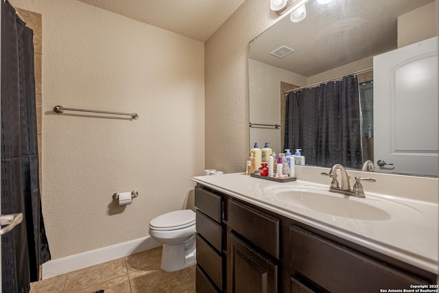 bathroom featuring tile patterned flooring, vanity, and toilet