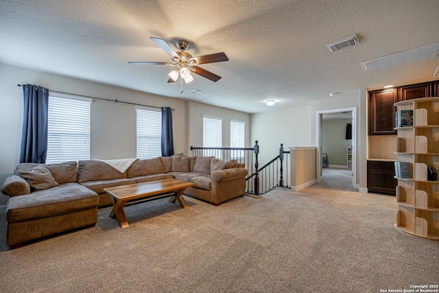 carpeted living room with ceiling fan and a textured ceiling