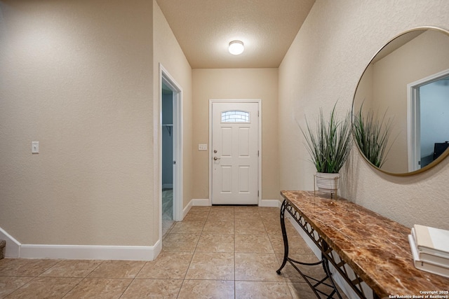 entryway featuring light tile patterned flooring and a textured ceiling