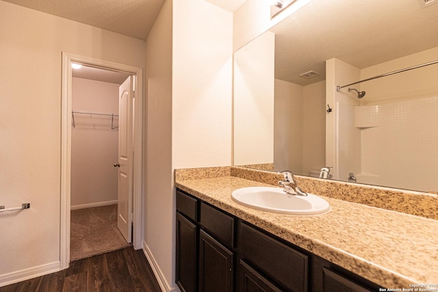 bathroom with vanity, hardwood / wood-style floors, and walk in shower