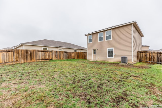 back of property with cooling unit and a yard