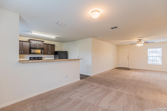 kitchen with ceiling fan, carpet, dark brown cabinetry, black appliances, and kitchen peninsula