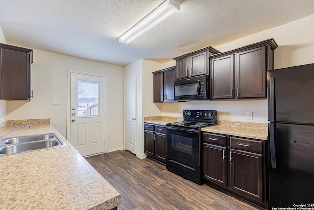 kitchen with sink, dark brown cabinets, a textured ceiling, dark hardwood / wood-style flooring, and black appliances