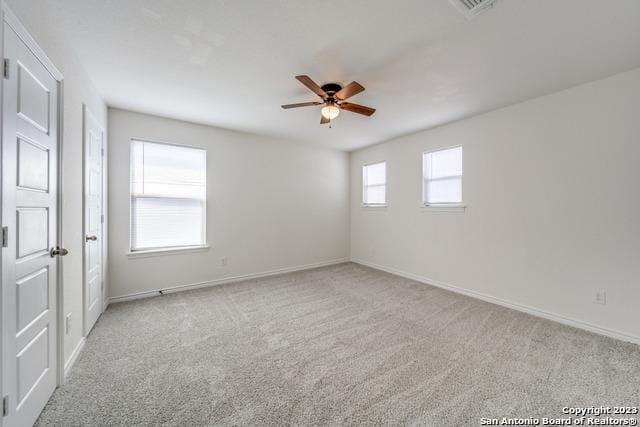 spare room with light carpet and ceiling fan