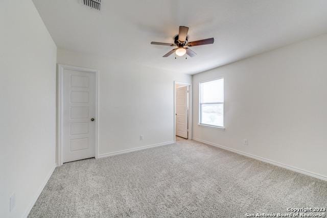 spare room featuring light colored carpet and ceiling fan