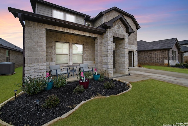 view of front of home featuring cooling unit, a lawn, and a porch