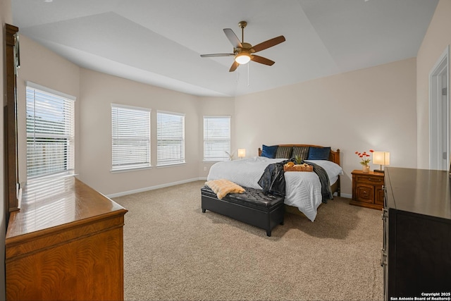 carpeted bedroom with lofted ceiling, ceiling fan, and a tray ceiling