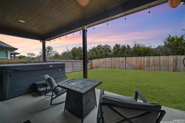 patio terrace at dusk with an outdoor fire pit and a yard