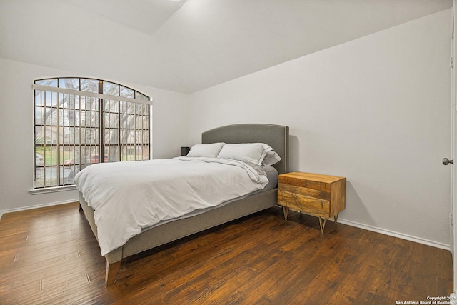 bedroom with lofted ceiling and dark hardwood / wood-style floors