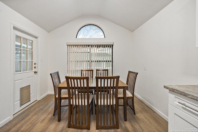 dining room with dark hardwood / wood-style floors and vaulted ceiling