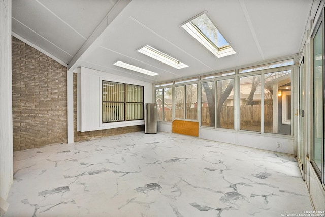 unfurnished sunroom featuring vaulted ceiling with skylight