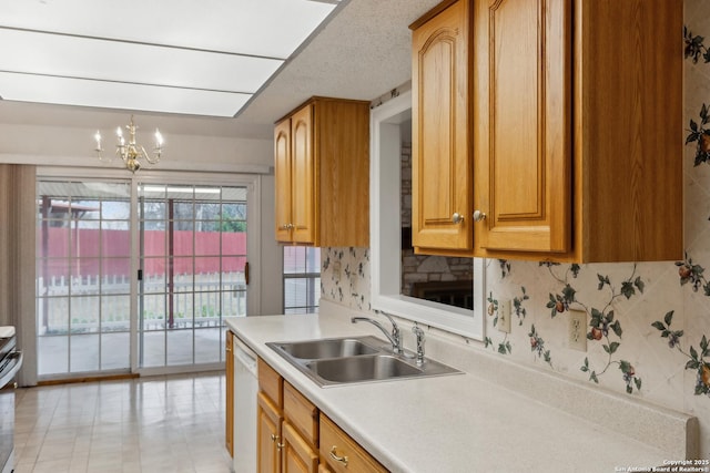 kitchen with sink, tasteful backsplash, a chandelier, hanging light fixtures, and white dishwasher