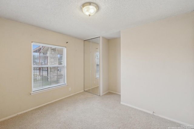 carpeted spare room featuring a textured ceiling