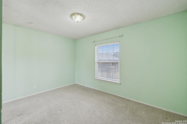 unfurnished room with carpet and a textured ceiling