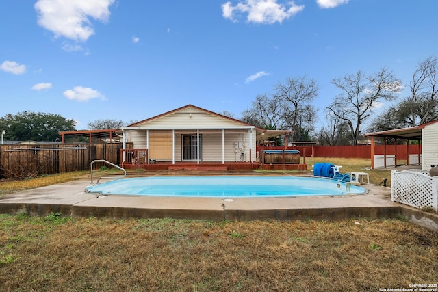 view of swimming pool with a wooden deck, a yard, and a hot tub