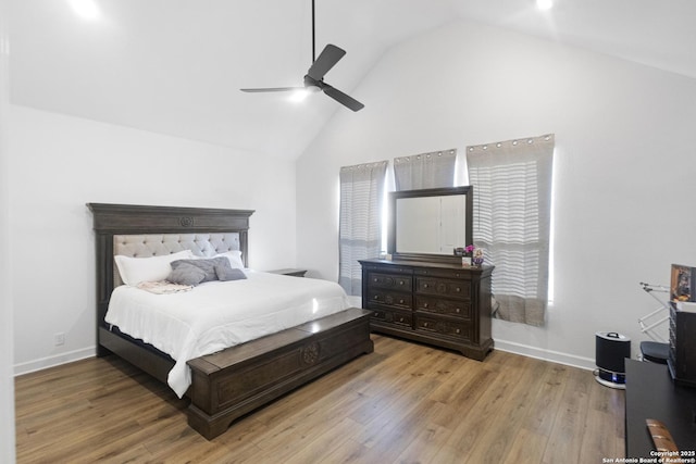 bedroom with ceiling fan, high vaulted ceiling, and light wood-type flooring