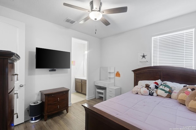 bedroom featuring light hardwood / wood-style flooring, ceiling fan, and ensuite bathroom