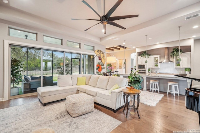 living room featuring light wood finished floors, visible vents, a ceiling fan, and recessed lighting