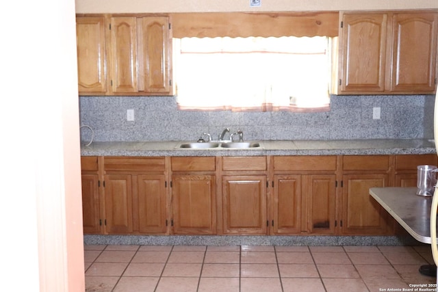 kitchen with sink, light tile patterned floors, and backsplash