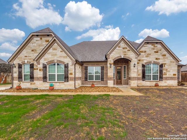 french provincial home with a front yard