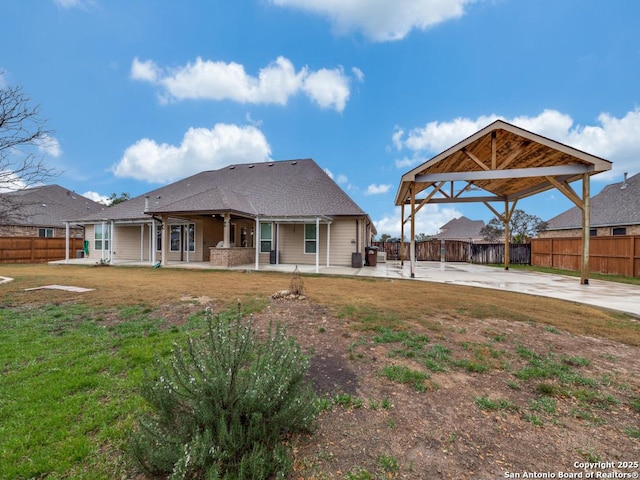 back of property featuring a patio, a yard, and a gazebo