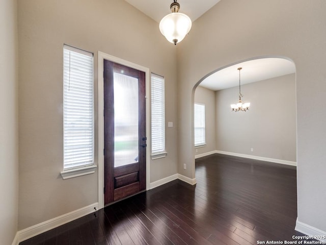 foyer entrance featuring an inviting chandelier and dark hardwood / wood-style floors