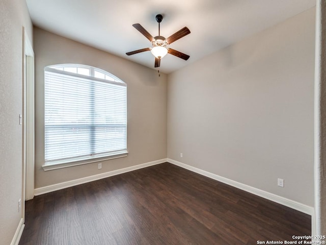 empty room with ceiling fan and dark hardwood / wood-style flooring