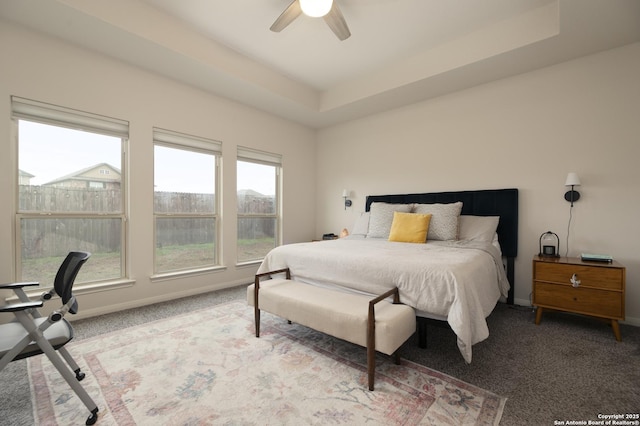 bedroom featuring ceiling fan, carpet flooring, and a raised ceiling