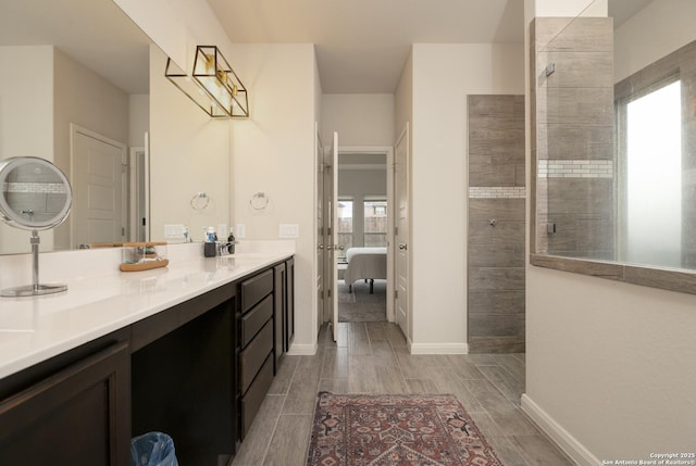 bathroom with tiled shower and vanity