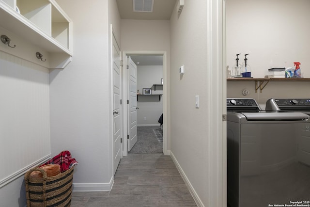 clothes washing area with hardwood / wood-style flooring and independent washer and dryer