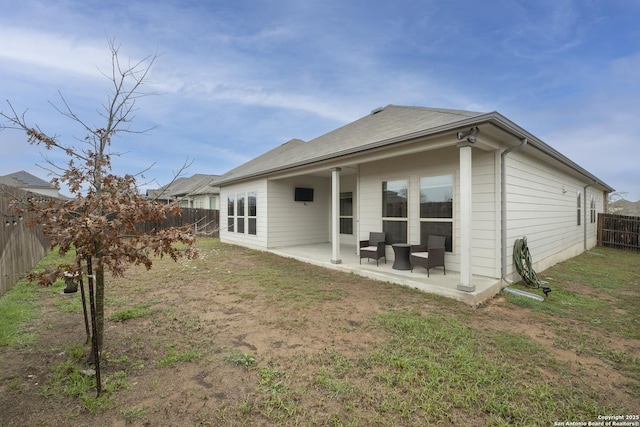 back of house with a patio and a lawn