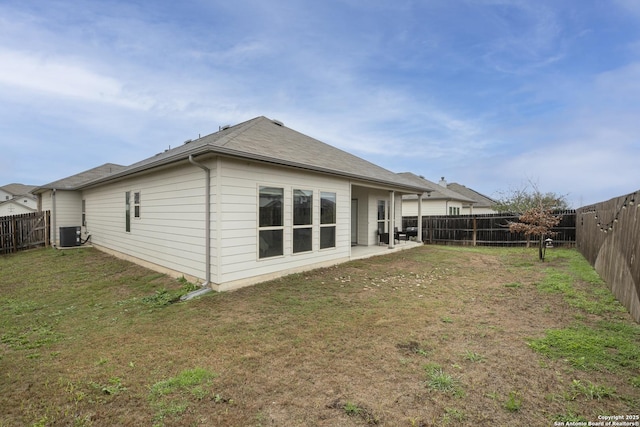 rear view of house with a lawn, central air condition unit, and a patio area