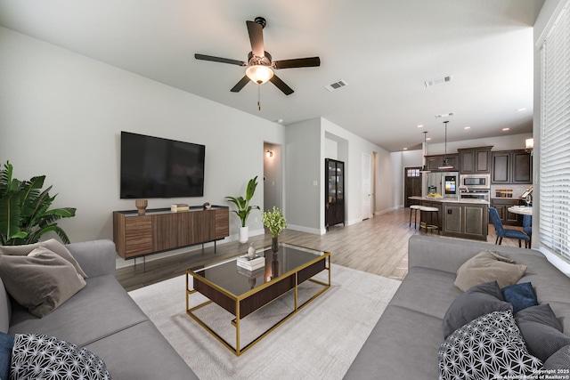 living room featuring ceiling fan and light hardwood / wood-style floors