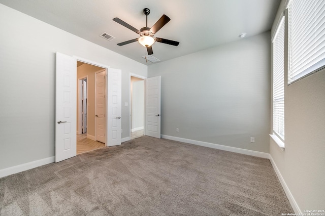 unfurnished bedroom featuring ceiling fan, light colored carpet, and multiple windows