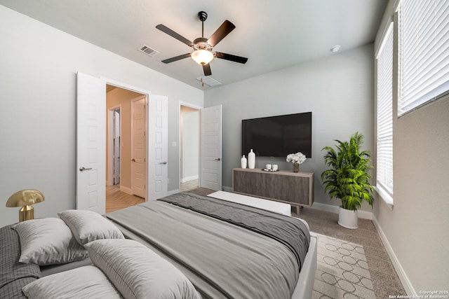 carpeted bedroom with multiple windows and ceiling fan