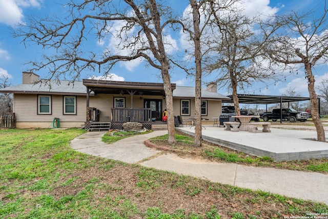 view of front of property featuring a front lawn, a carport, and covered porch