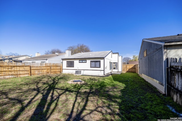 back of house with a yard and central AC unit