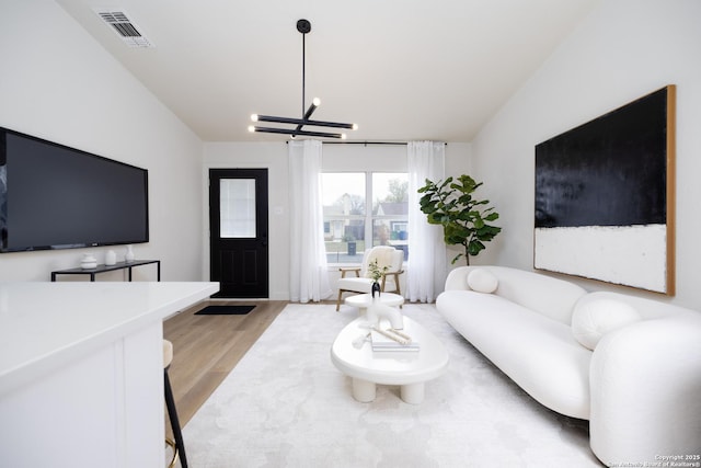 living room featuring a notable chandelier and light hardwood / wood-style flooring