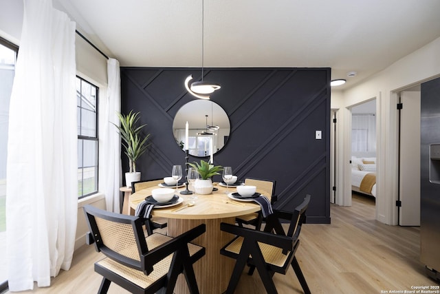 dining space with light hardwood / wood-style floors and a healthy amount of sunlight