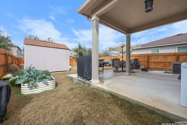 view of yard featuring a storage unit, central AC unit, and a patio area