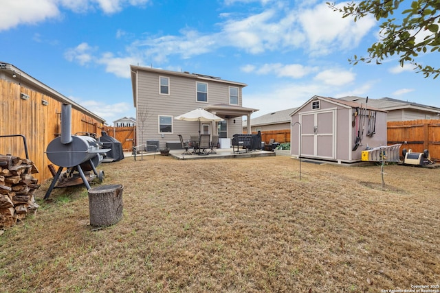 rear view of property featuring a shed, a patio area, and a lawn